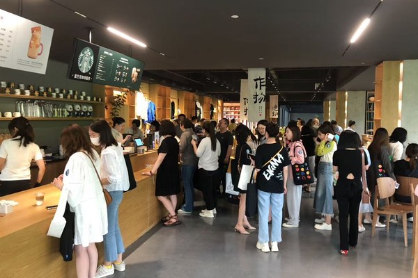 企业咖啡角现场——吧台前排队取咖啡的员工